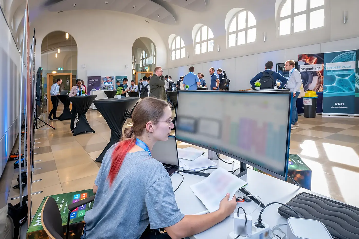 Technische Betreuung der MSE 2026 an einem zentralen Arbeitsplatz; private Bildschirm- und Papierinhalte sind unkenntlich