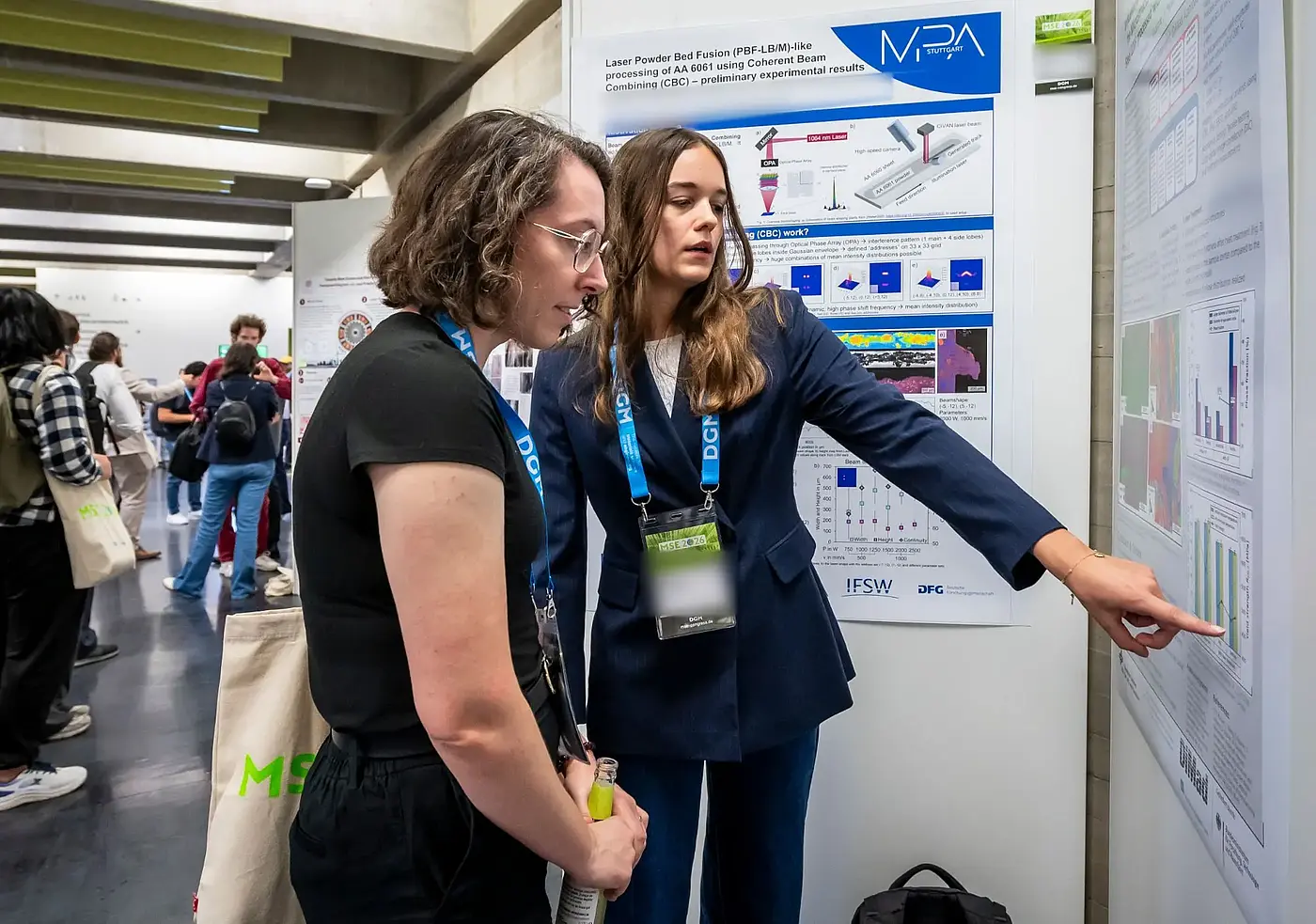 Two researchers discuss a poster at MSE 2026