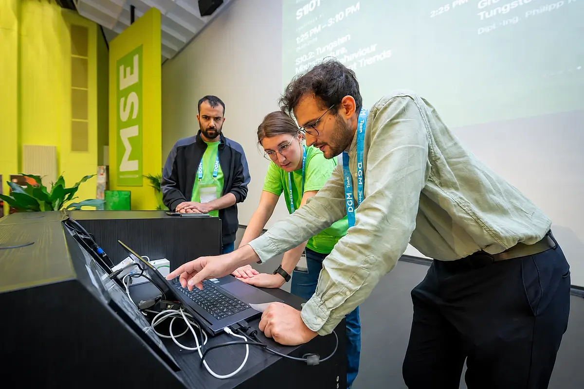 Das Saalteam der MSE 2026 bereitet gemeinsam eine Präsentation vor; Namen auf Badges sind unkenntlich