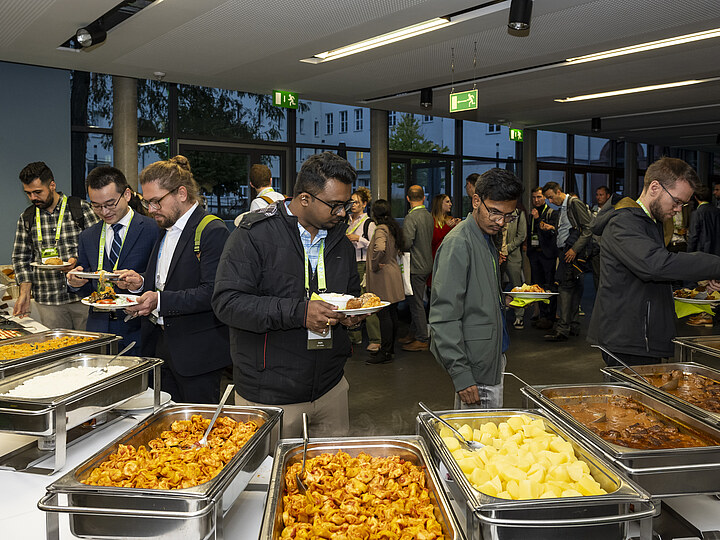 Teilnehmende wählen Speisen an einem Veranstaltungsbuffet