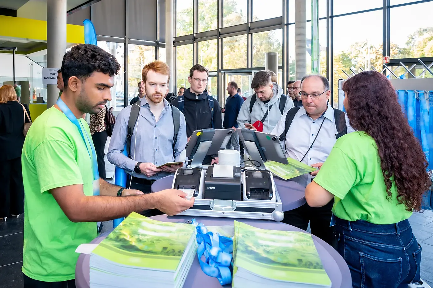 The reception team supports participants with distribution at the check-in stations