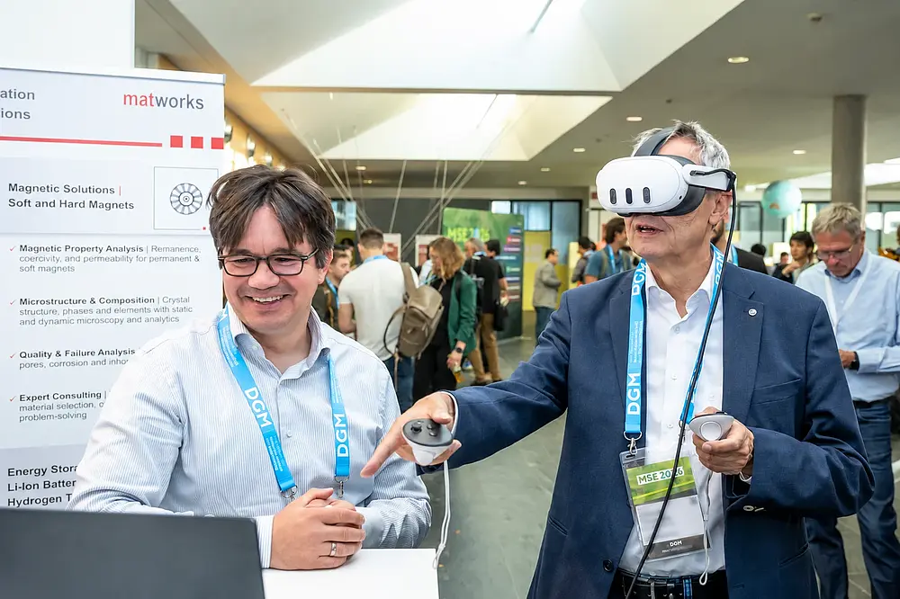 Zwei Teilnehmende erproben gemeinsam eine VR-Anwendung an einem Ausstellungsstand