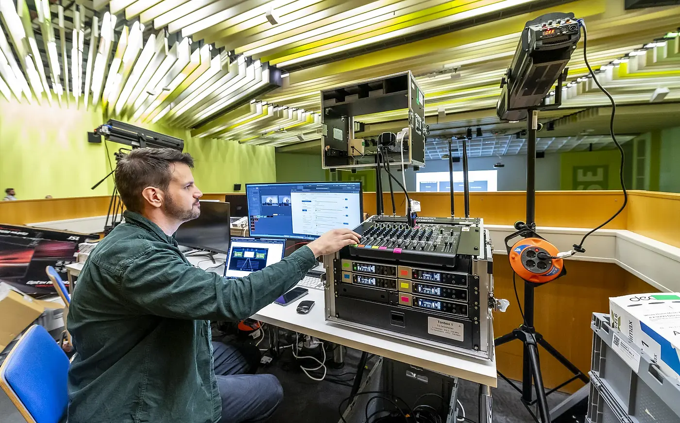 Technician managing video and audio at the production desk in the lecture hall