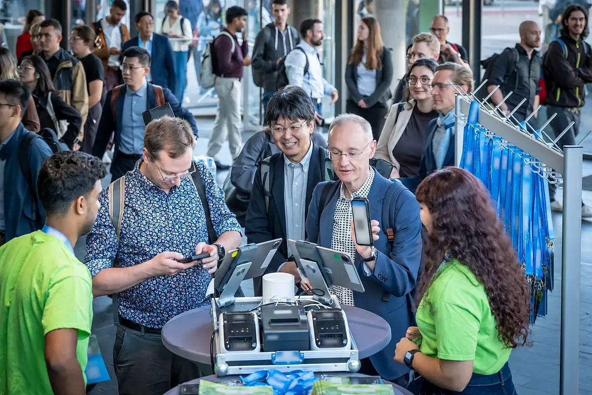 Participants show their personal code and are welcomed by the reception team; names and codes are obscured